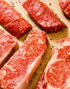 flatlay shot of cut slices of meat on wooden cutting board