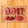 flatlay of six cut slices of steak on parchment paper